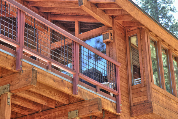 Inline image showing a wood deck wrapping a two story mountain home with modern iron fences. Designed and constructed by WhiteFace Builders in Truckee, CA.